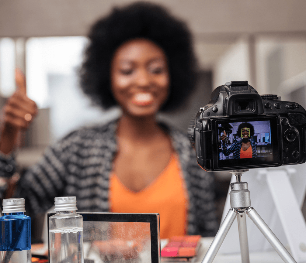 African American woman with curly hair looking positive while recording video